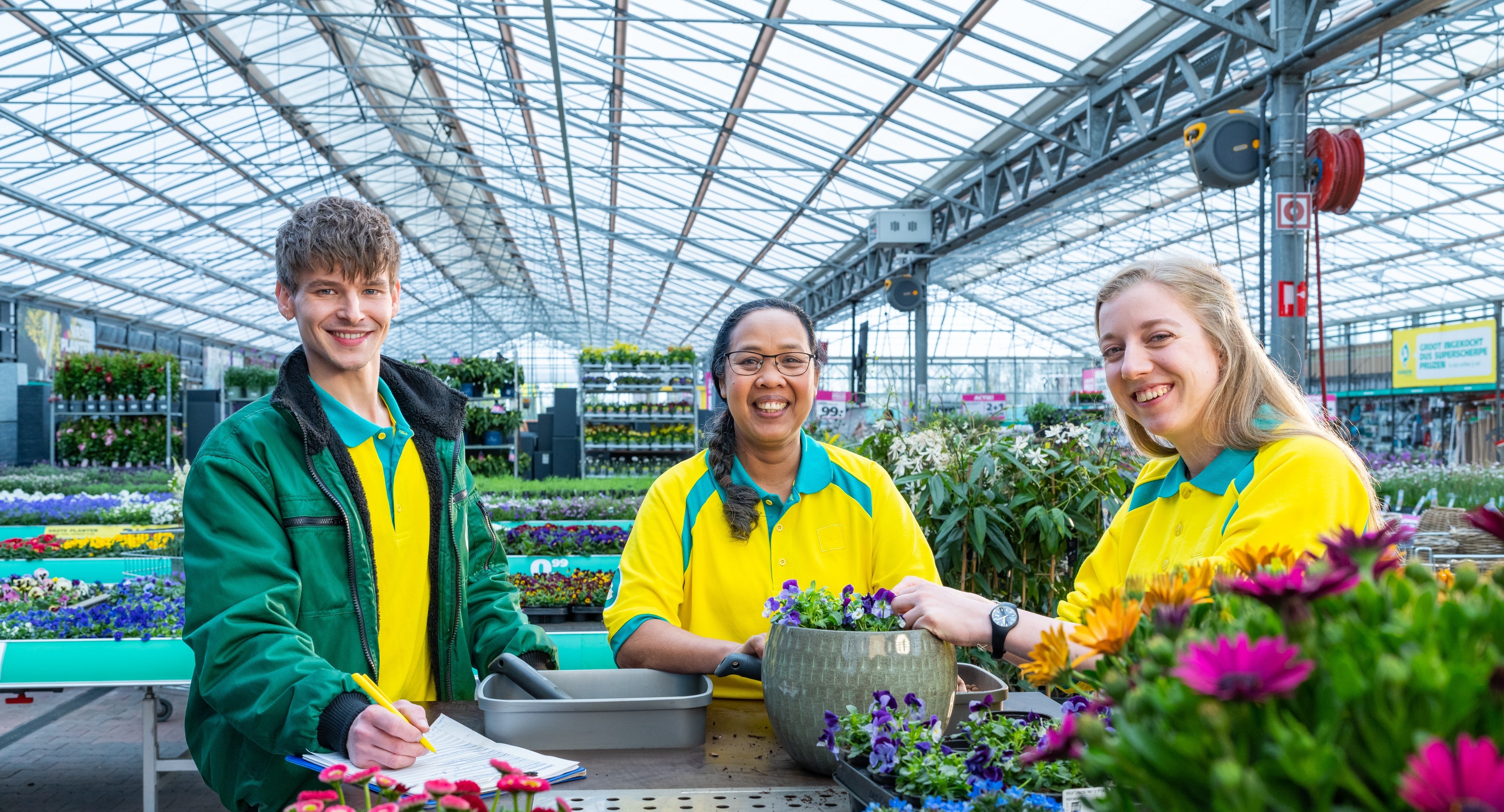 Medewerkers staan naast bloemen