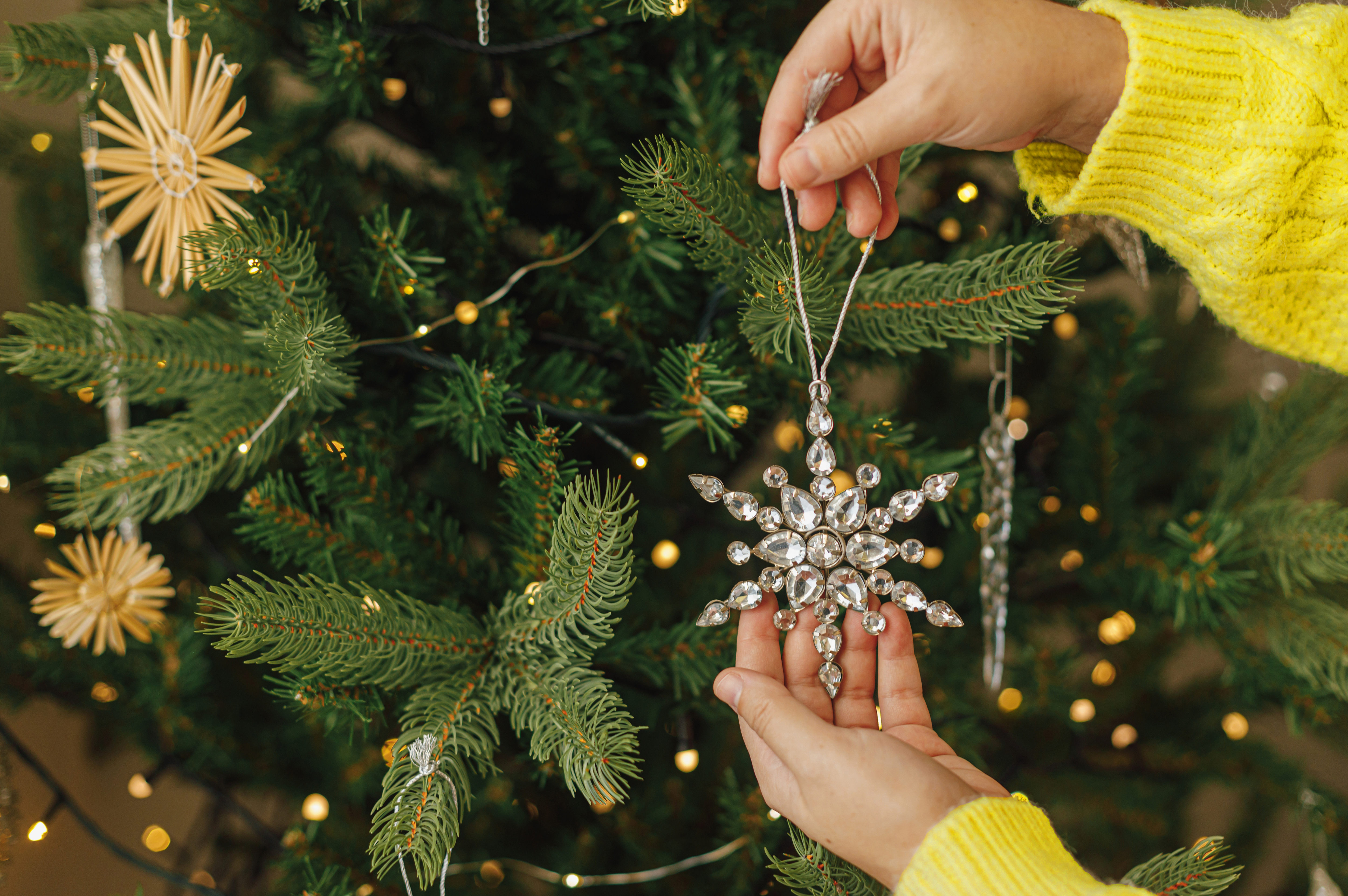 Vrouw hangt hanger op in kerstboom